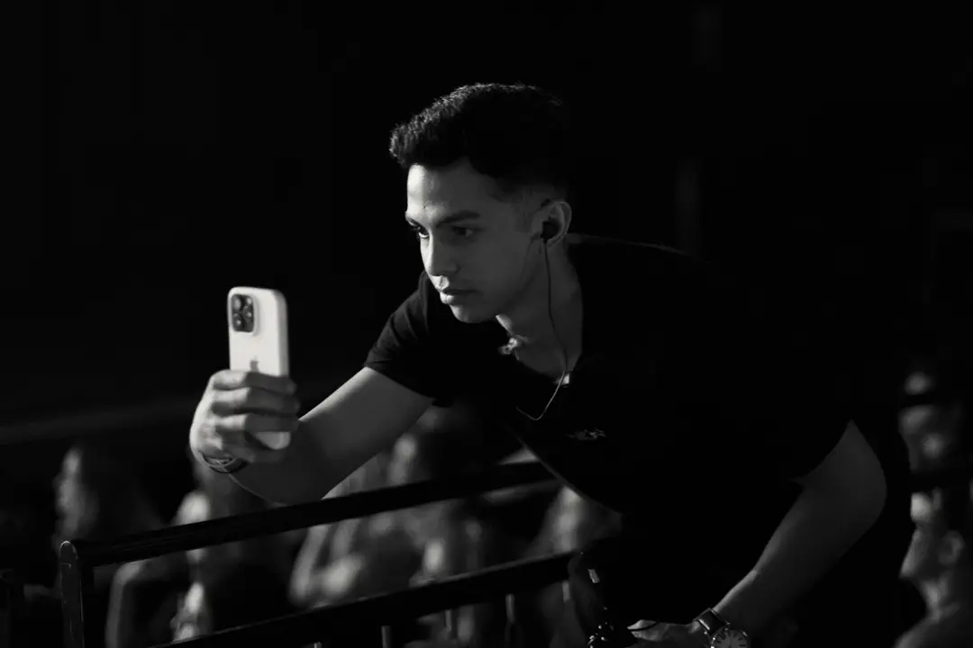 Em preto e branco, integrante da equipe filmando da plateia