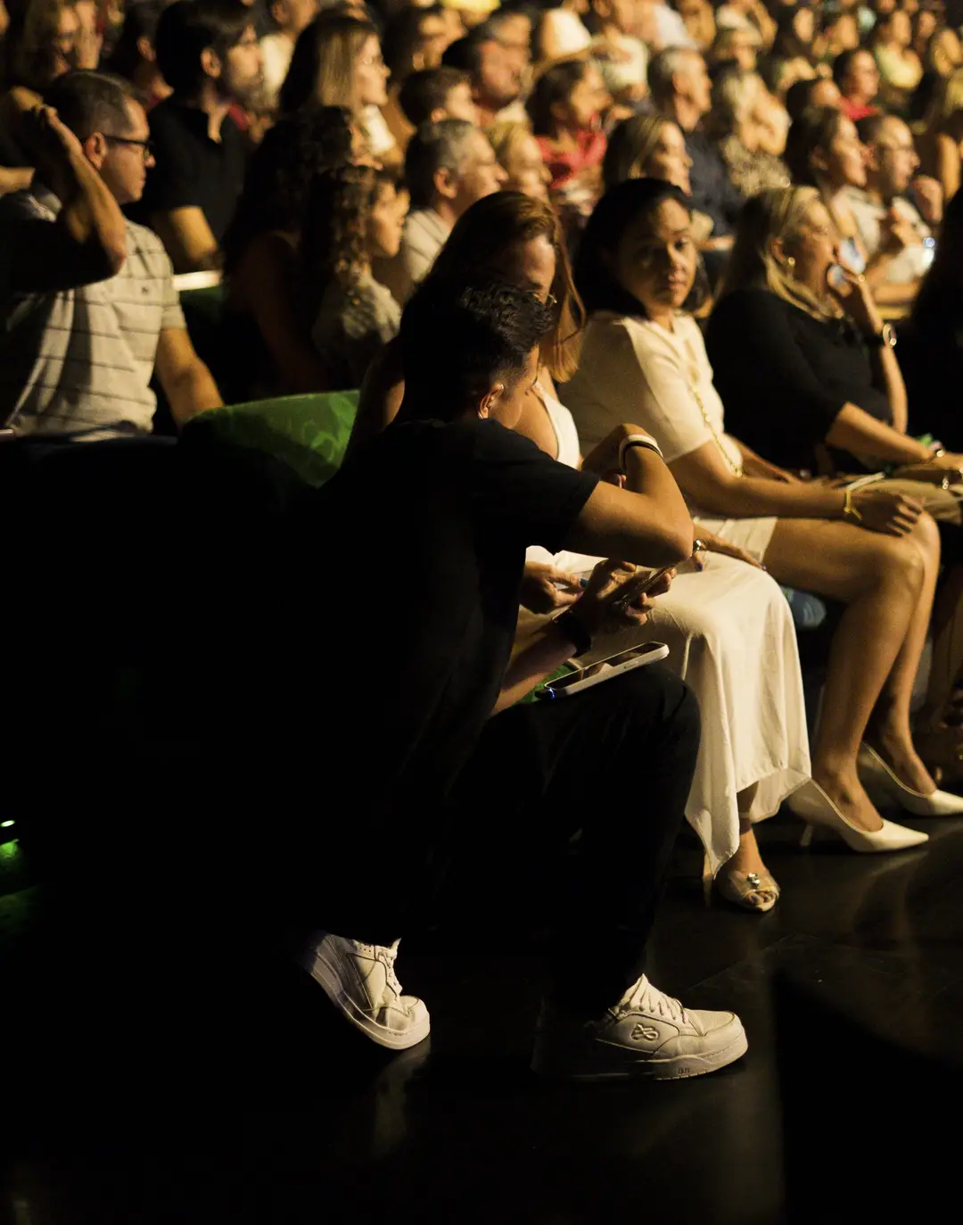 Integrante da equipe agachado no corredor da plateia