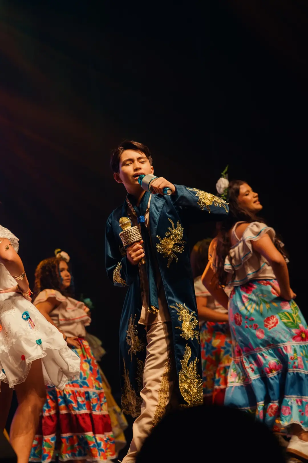 Aluno cantando com casaco bordado em dourado