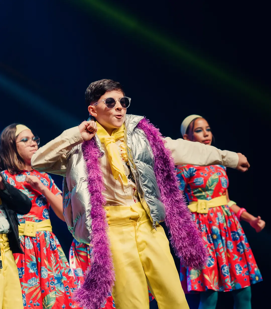 Aluno de terno amarelo e plumas no centro da coreografia